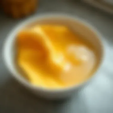 A close-up of a kitchen cloth being soaked in a bowl of soapy water.