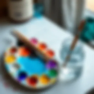 Palette with colors and a water container for cleaning brushes.
